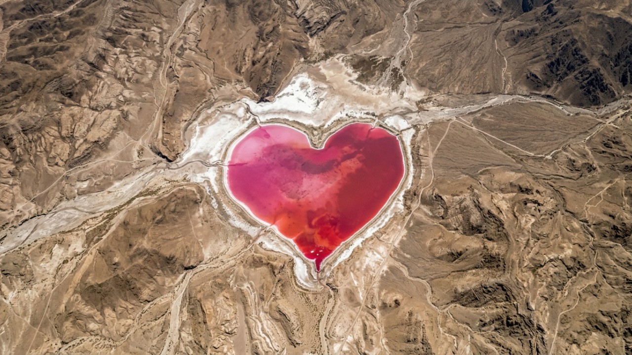 A coloração rosa da lagoa em Salinas Las Barrancas é resultado da presença de microrganismos halófilos em ambientes de alta salinidade. – Imagem gerada por IA